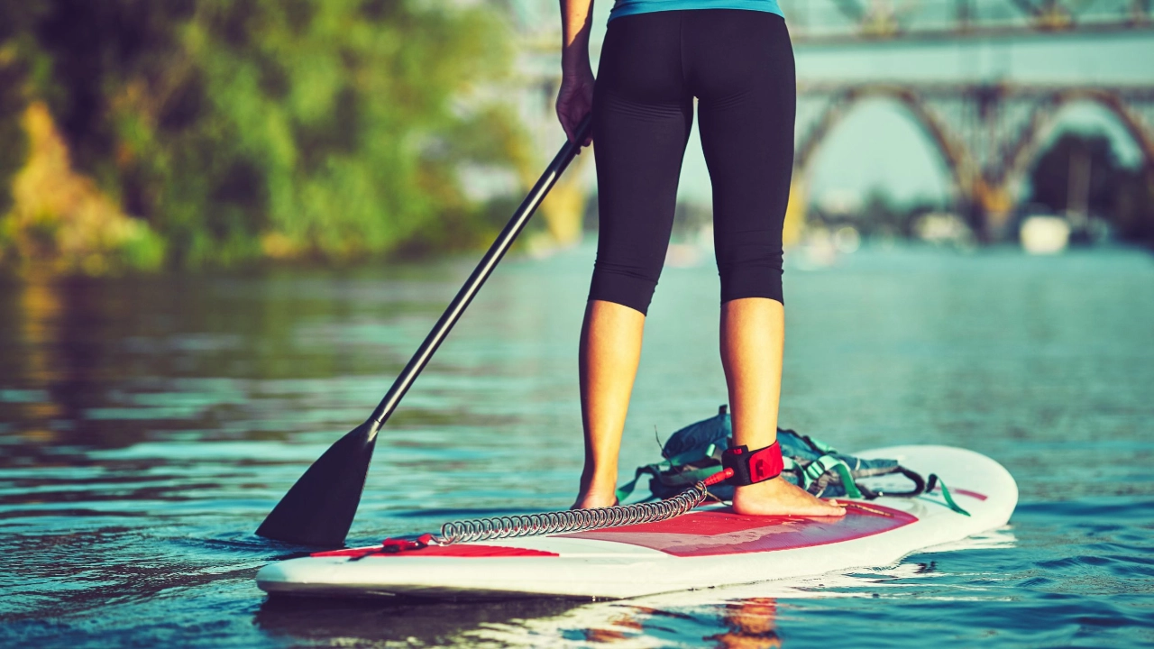 Frau mit Paddel auf Surfbrett