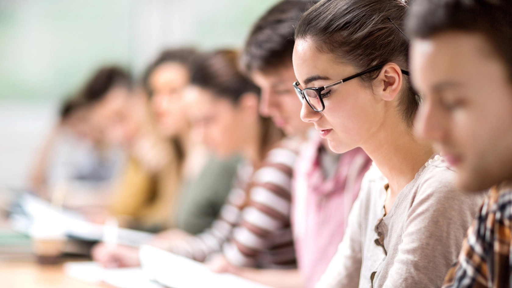 Eine Studentin schaut während eines Seminars auf ihre Notizen.
