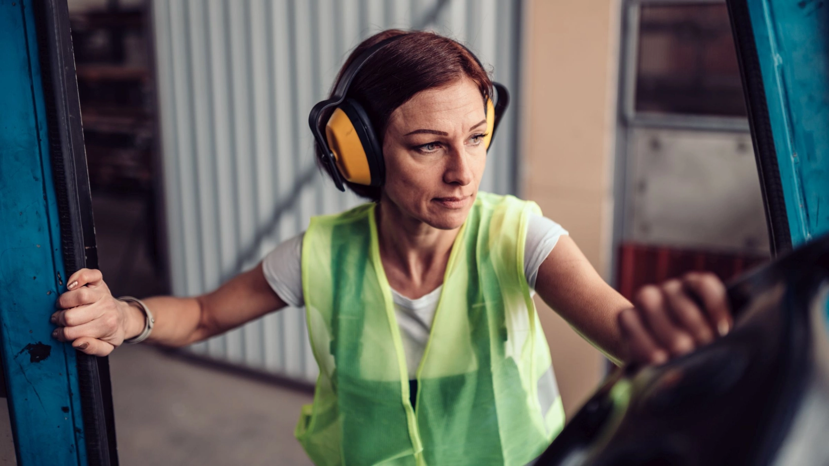 Arbeitnehmerin beim Einstieg in einen Gabelstapler