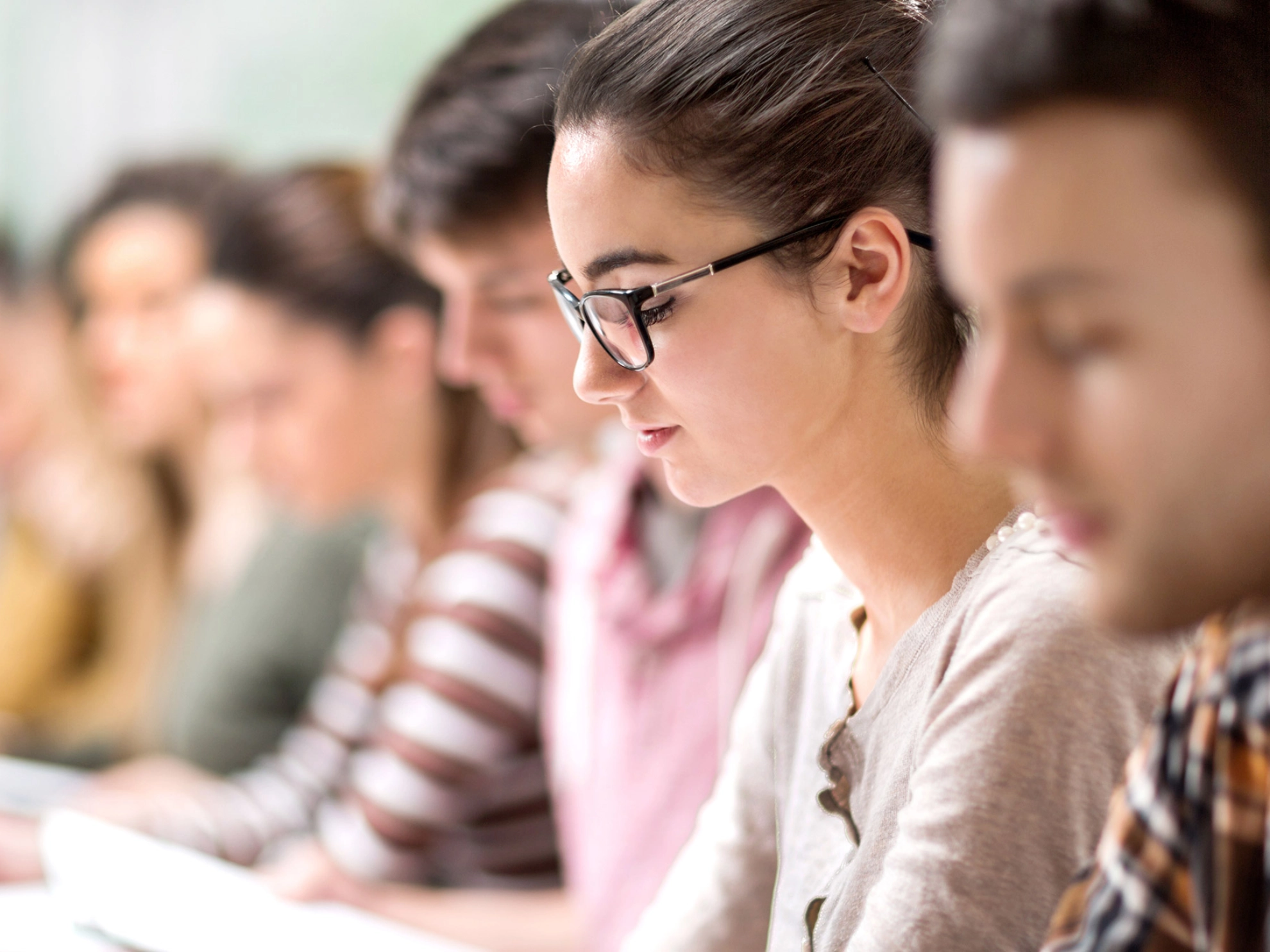 Eine Studentin schaut während eines Seminars auf ihre Notizen.