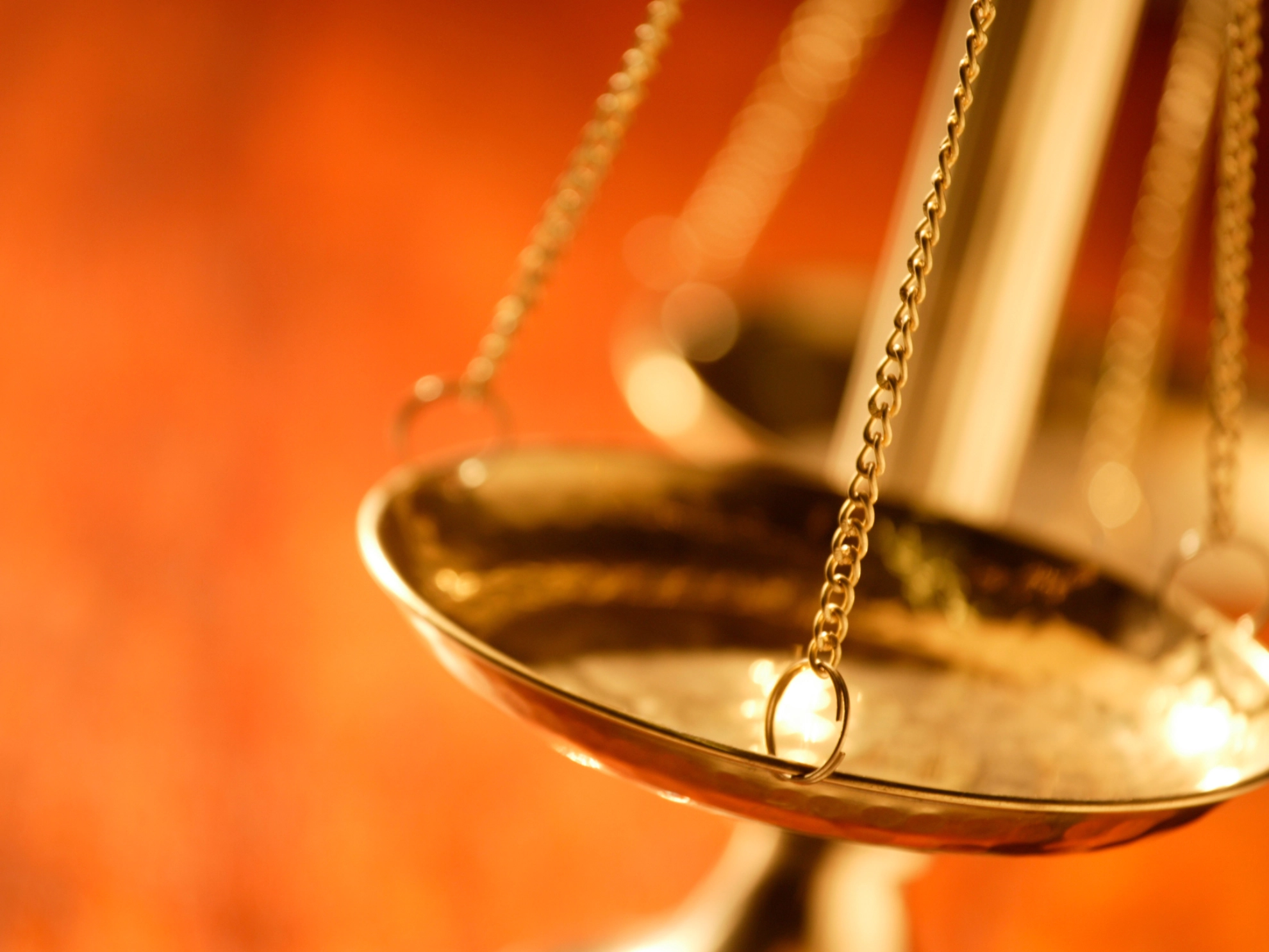 Eine goldene Waage vor unscharfem Hintergrund als Symbol für Recht und Gerechtigkeit