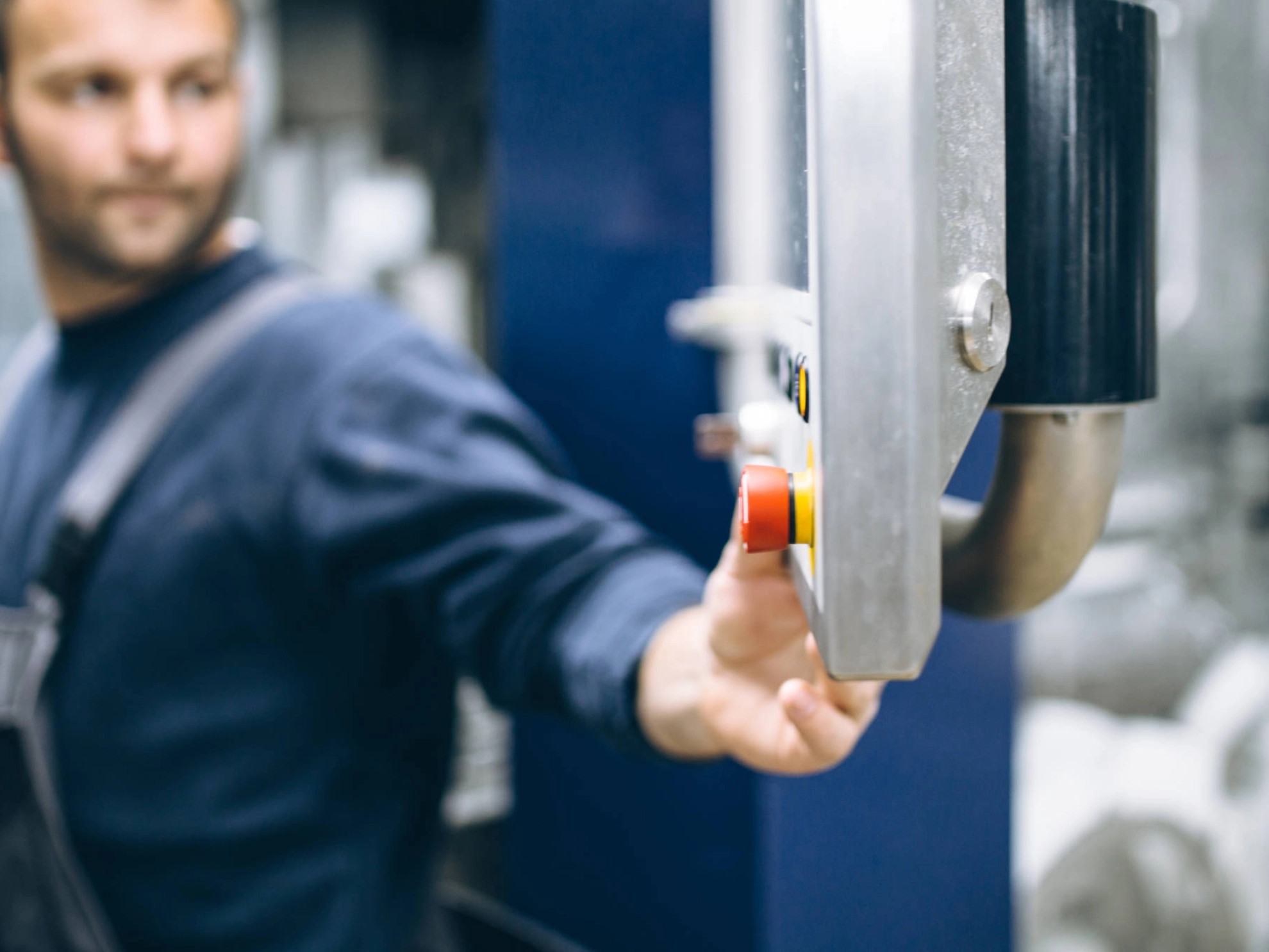 Ein Mann drückt auf einen roten Knopf.