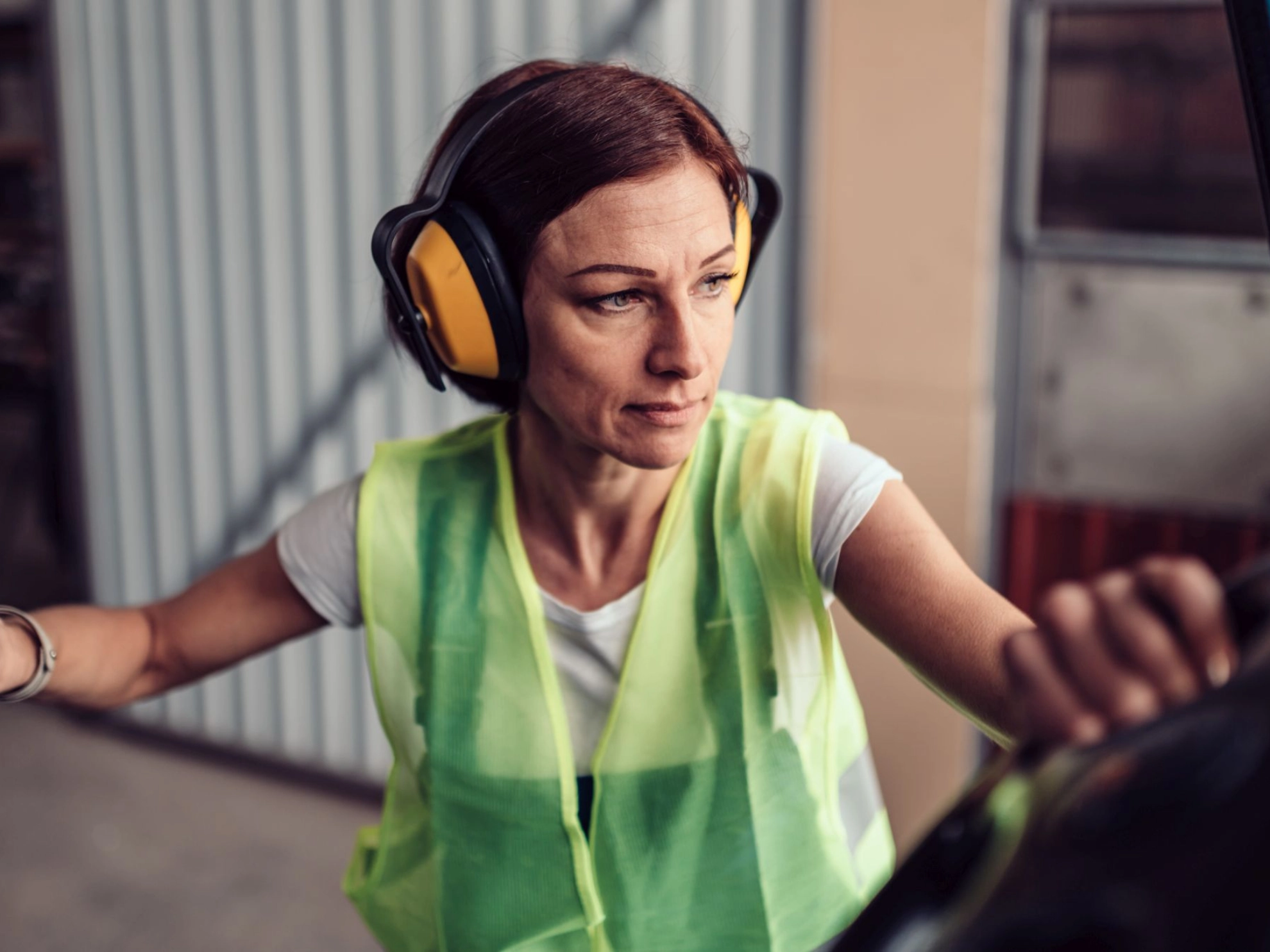 Arbeitnehmerin beim Einstieg in einen Gabelstapler