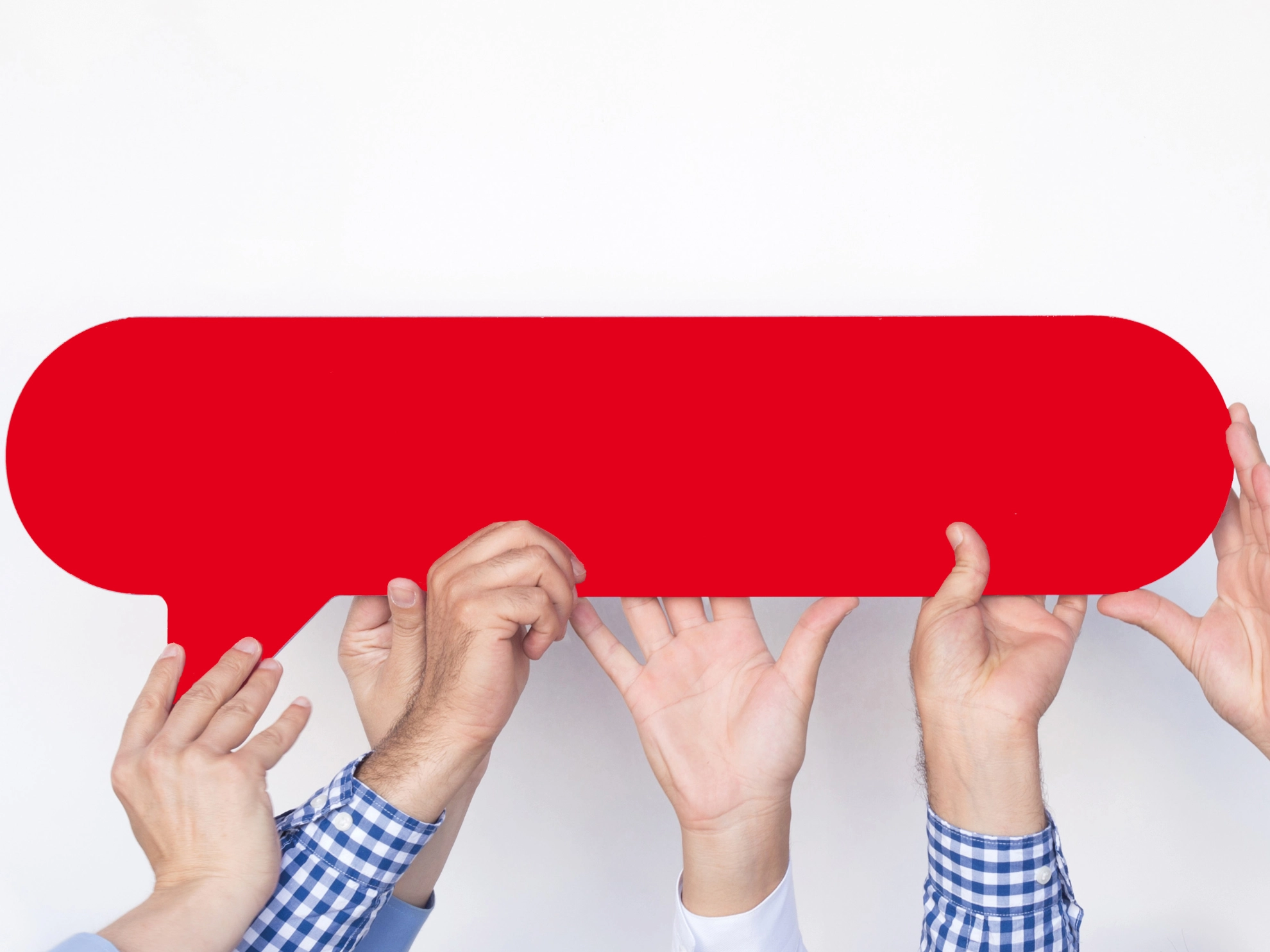 Vier Hände halten eine rote Sprechblase nach oben.