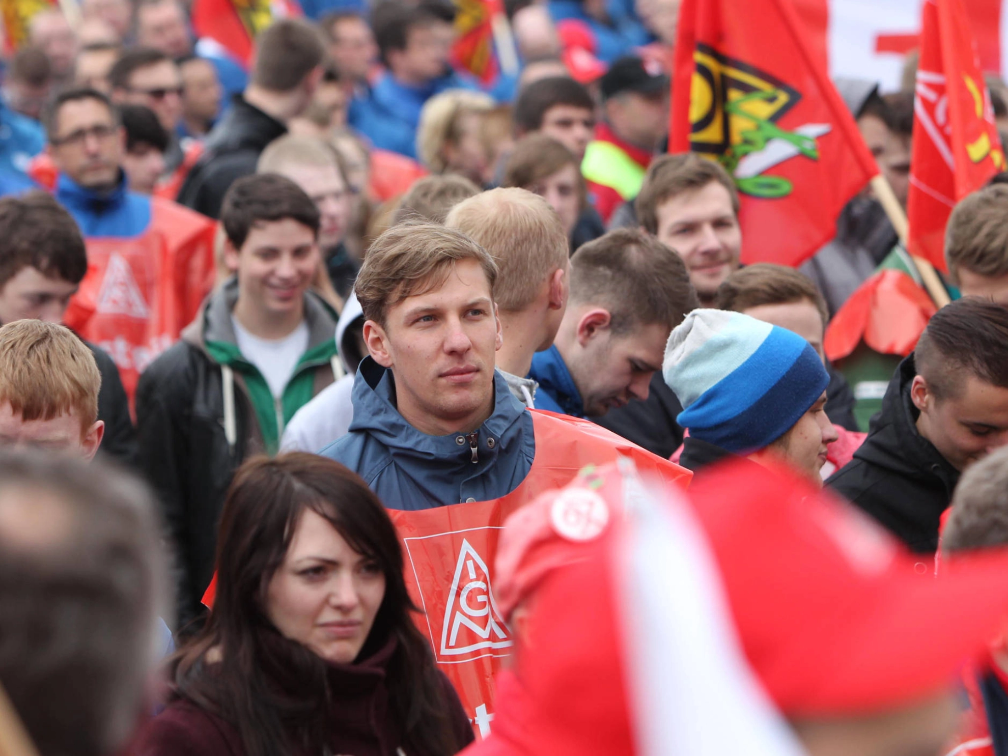 Ein junger Mann steht bei einer Menschenmenge.