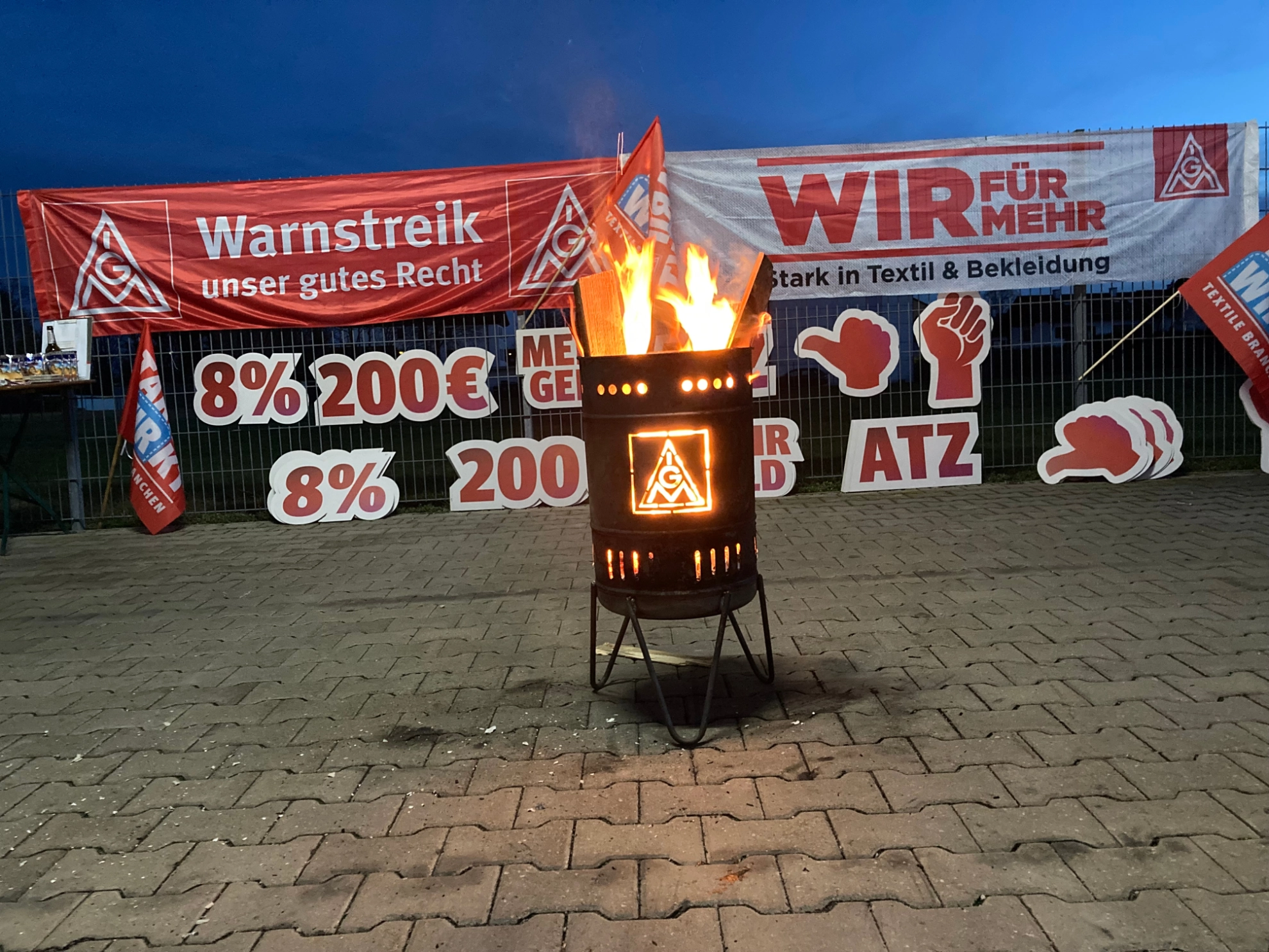 Feuertonne vor Plakaten - es ist Nacht
