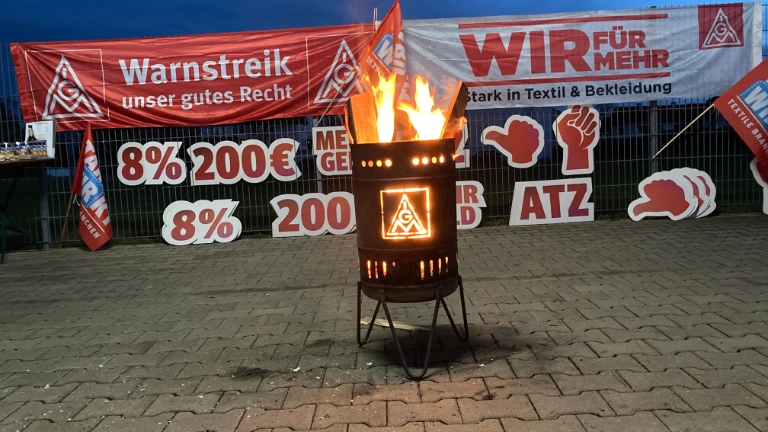 Feuertonne vor Plakaten - es ist Nacht